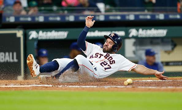 Jose Altuve #27 of the Houston Astros scores on a double by Evan Gattis #11 in the first inning against the Toronto Blue Jays at Minute Maid Park on June 27, 2018 in Houston, Texas.