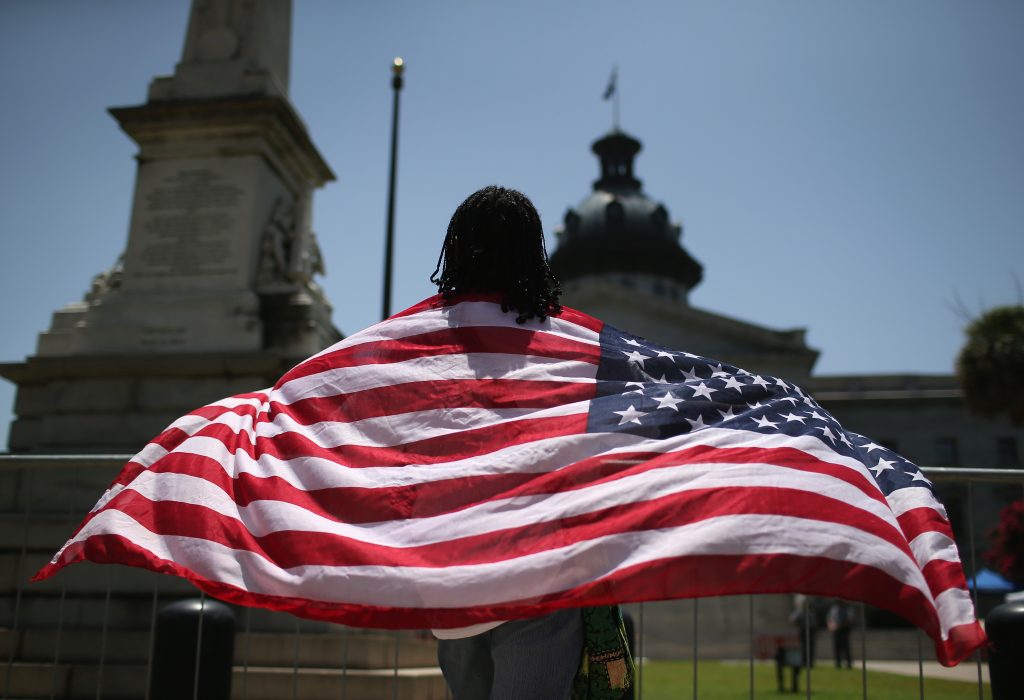 COLUMBIA, SC - JULY 10: South Carolinan Brenda Brisbon wears the "Stars and Stripes" after the Confederate "Stars and Bars" was lowered from the flagpole in front of the statehouse on July 10, 2015 in Columbia, South Carolina. Republican Governor Nikki Haley presided over the flag-lowering event after signing the historic legislation to remove the flag the day before. 