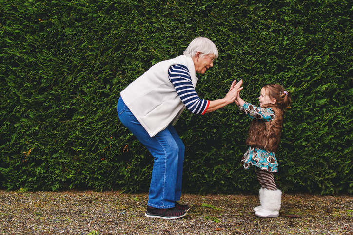 Girl playing pat-a-cake with her grandmother