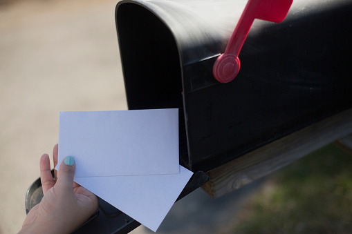 Cropped Image Of Woman Removing Letter From Mailbox