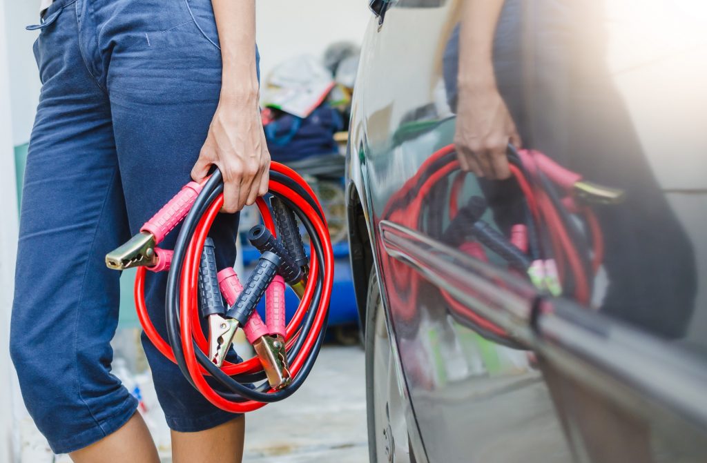 Woman holding jumper cables