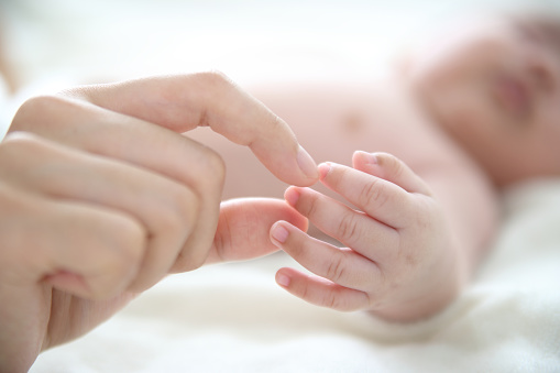 Mom holds baby hand