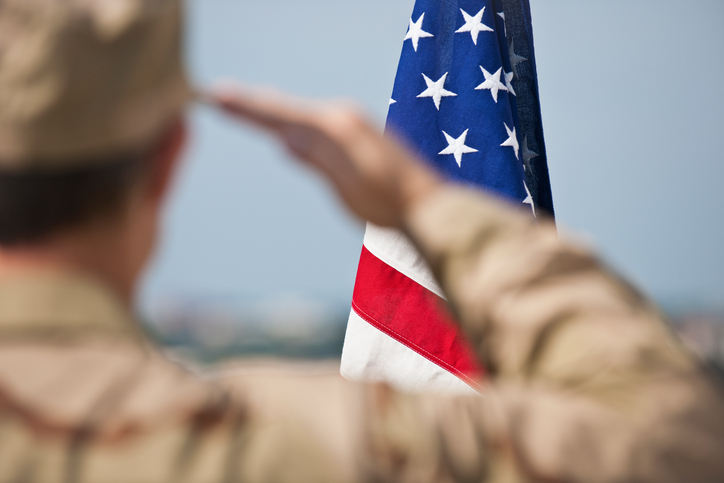 Soldier saluting an American flag