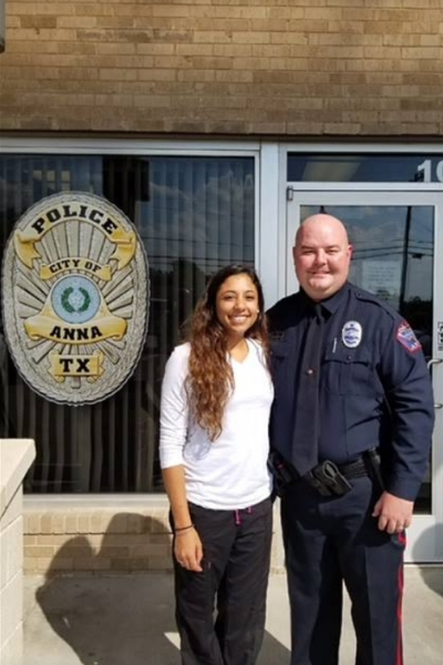 A police officer stands next to the woman he saved.