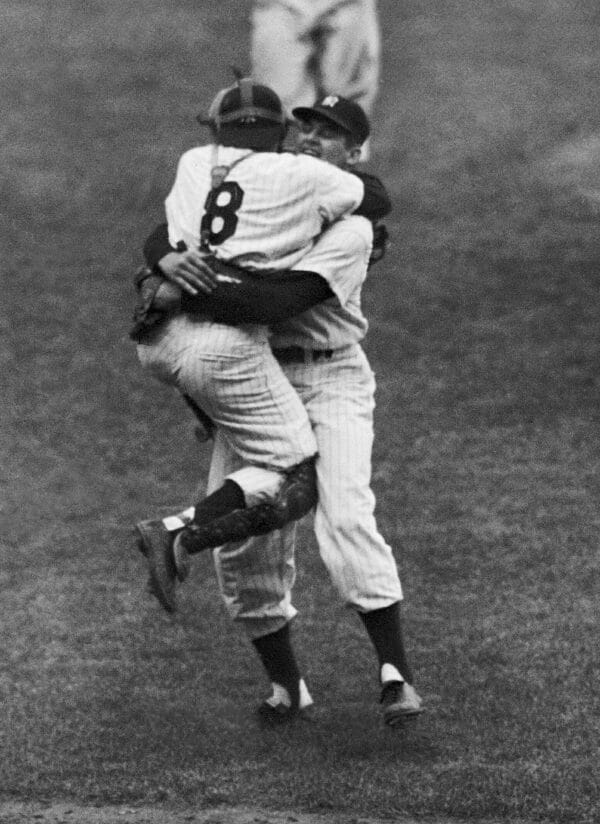 New York Yankees catcher Yogi Berra leaps into the arms of pitcher Don Larsen after Larsen struck out the last Brooklyn Dodgers batter to complete his perfect game.